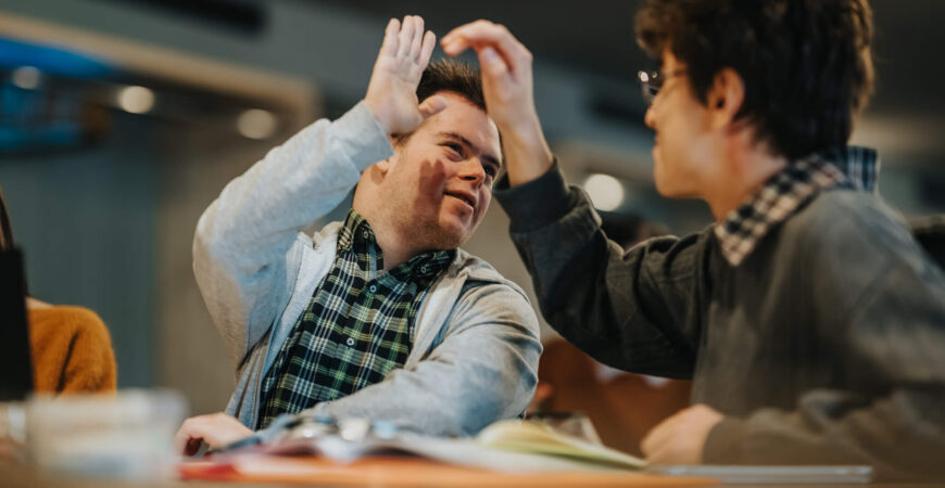person with downs syndrome high fiving friend